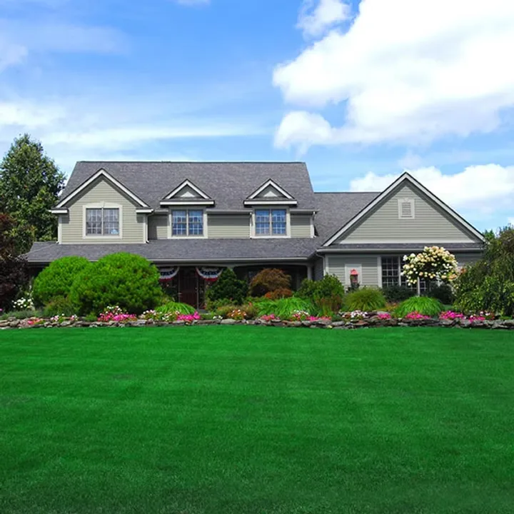 A front lawn cut and edged on the weekly route, beds tidy against the house